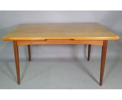 A 20th century teak drop end extending table on tapering supports, 135cm wide x 73cm high  x 235cm fully extended, a set of f