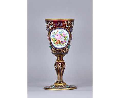 A Bohemian ruby glass enamelled chalice, late 19th century, with foliate painted enamel oval, bordered by coloured jewels aga