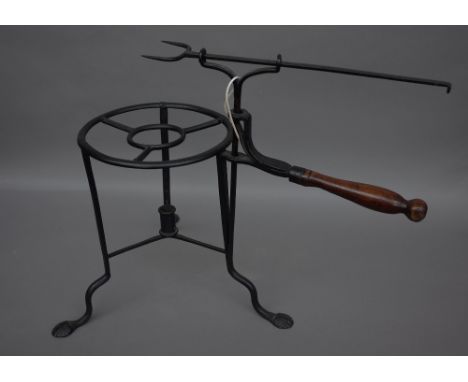 A rare late 18th century wrought iron toasting trivet, with adjustable two prong fork over a circular triform base, the legs 