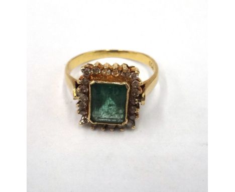 A gold, emerald and diamond rectangular cluster ring, mounted with the cut cornered rectangular step cut emerald at the centr