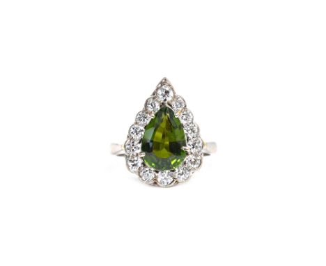 A white gold, green tourmaline and diamond set pear shaped cluster ring, claw set with the pear shaped green tourmaline at th