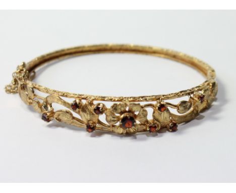9ct gold hinged bangle with garnets.