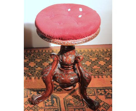 Victorian carved walnut circular tripod piano stool, 52cm high.