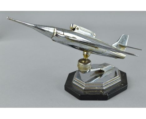 A CHROME PLATED DESK TOP LIGHTER, in the form of a jet fighter aircraft, c.1960's, no makers marks, on a bakelite stand, some