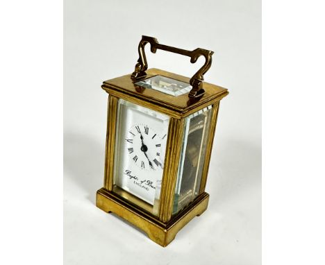 A Brights of Bristol miniature brass four glass clock with enamelled dial and arabic numerals, raised on bracket feet (8cm x 