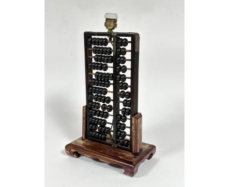 A stained Chinese upright abacus framed table lamp, the abacus of earlier origin with metal straps and turned beads, on recta