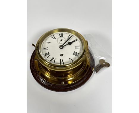 An Edwardian style brass ships wall clock with enamel dial and subsidiaries dial, complete with key aperture and Roman numera