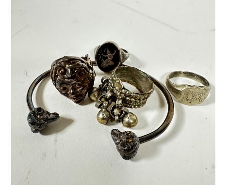A silver cast bangle with ram's head terminals, a silver signet ring with engraved initials, a white metal portrait style cas