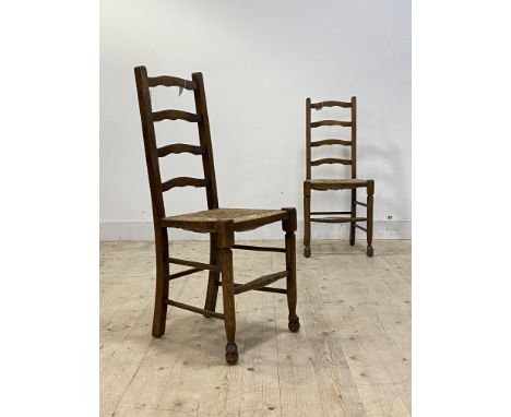 A pair of early 20th century oak ladder back chairs, with rush seats and turned supports, H100cm, W43cm, D39cm