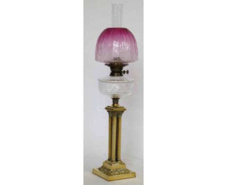 Brass Corinthian cluster column table oil lamp with a cut glass reservoir and pink glass shade, height to burner 55cm.
 
Cond