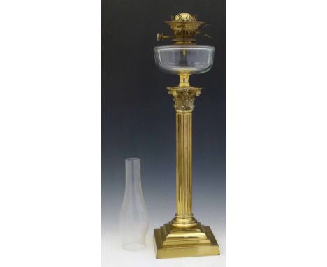 Victorian brass Corinthian column table oil lamp with colourless glass reservoir, height to burner, 63cm.