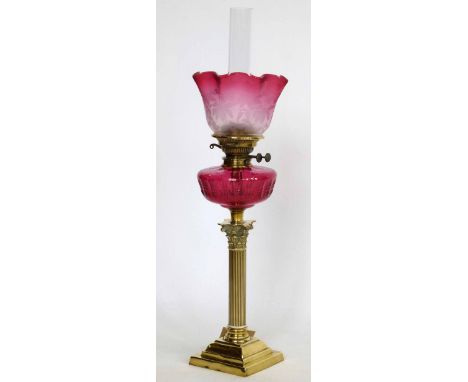 Brass Corinthian column table oil lamp with a ruby glass reservoir and frosted trumpet shade, height to burner 52cm
 
Conditi