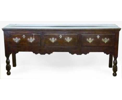 Oak dresser base of three short drawers with replacement brass plates on turned baluster legs, length 196cm.