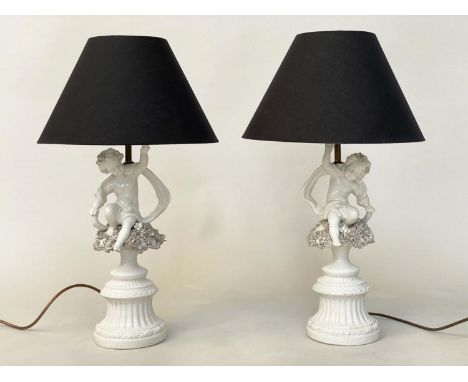 TABLE LAMPS, a pair, 20th century Italian white ceramic, each with seated cupid support (old repairs) with shades, 61cm H. (2