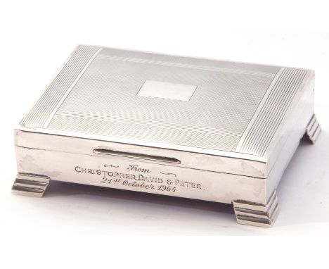 Silver table-top cigarette box, hinged lid with engine turned decoration, presentation engraved front, standing on four stepp