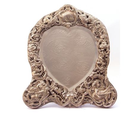 Victorian mirror in a silver frame, the heart-shaped bevelled mirror within an elaborately embossed frame decorated with mask