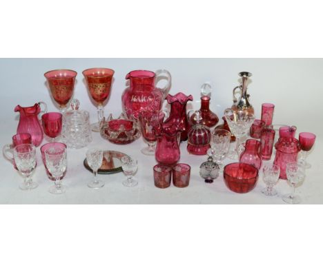 A collection of cranberry glass pieces, to include wine glasses, scent bottles, an advertising water jug 'Haigs Old Scotch' a