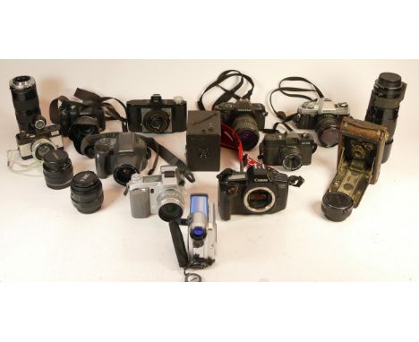 A collection of mixed cameras and accessories to include two digital camcorders, a Nikon 300mm lens and four vintage film SLR