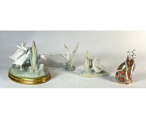 Two Lladro figures of birds, with a Nao example and a Royal Crown Derby paperweight of a seated cat, 13cm tall (4) 