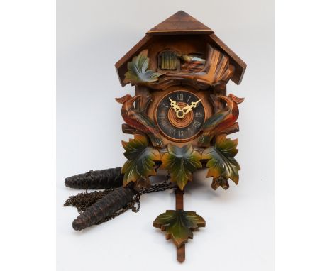 A mid 20th century Black Forest cuckoo clock, with bird and leaf surmount, twin weights and mechanical 30 hour movement. 