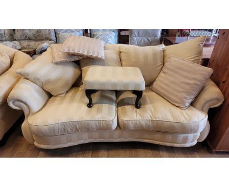 A modern two seater sofa, the shaped back with scatter cushions and removable shaped cushion seats, upholstered in a cream an