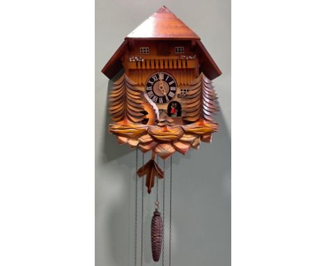 A Black Forest cuckoo clock, in the form of a Swiss chalet, the two train musical movement with automated figures and water w