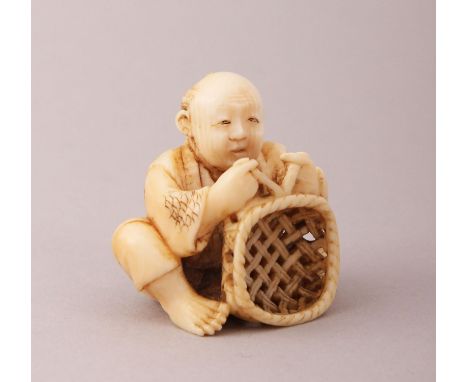 A GOOD JAPANESE MEIJI PERIOD CARVED IVORY NETSUKE OF A BASKET WEAVER, sat with his legs crossed in the process of weaving a b