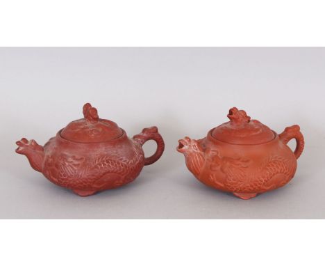 A GOOD PAIR OF 17TH/18TH CENTURY MOULDED ZISHA YIXING POTTERY TEAPOTS &amp; COVERS, circa 1690, the sides of each moulded wit