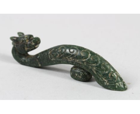 A CHINESE GREEN JADE BELT BUCKLE, in the form of a dragon, 11cm wide.