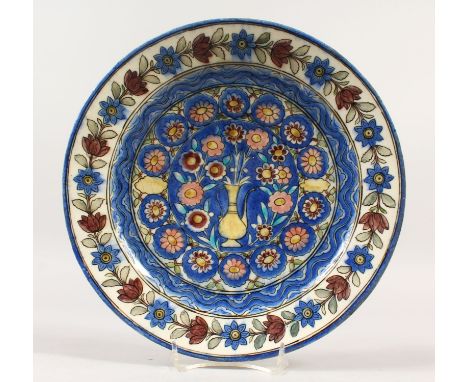 A 19TH CENTURY ISNIK CERAMIC POTTERY DISH, the dish profusely decorated with scenes of flora, 29.5cm diameter, 5cm high.