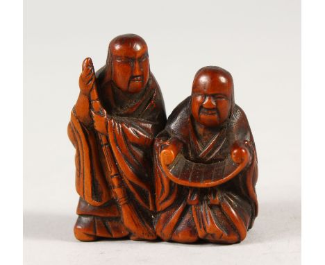 A JAPANESE BOXWOOD NETSUKE, depicting two scholars reading a scroll, artist signed to foot, Meiji period, 4cm high, 3.8cm wid