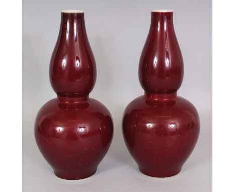 A PAIR OF CHINESE COPPER RED DOUBLE GOURD PORCELAIN VASES, each base with a six-character Kangxi mark, 26.6cm high.