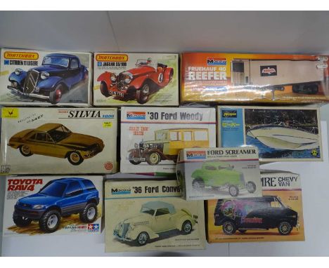 A group of unbuilt 1:24 and 1:32 scale plastic kits by MATCHBOX, MONOGRAM, TAMIYA etc - contents unchecked but appear complet