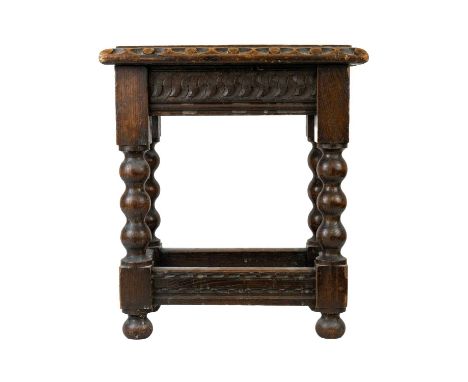 A Victorian oak small stool. The top with pierced centre, on bobbin turned square section legs, height 46cm, width 40.5cm, de