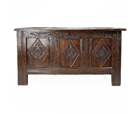 A 17th century oak coffer. The front panels each carved with a lozenge, height 69cm, width 129cm, depth 56cm.There are two bl