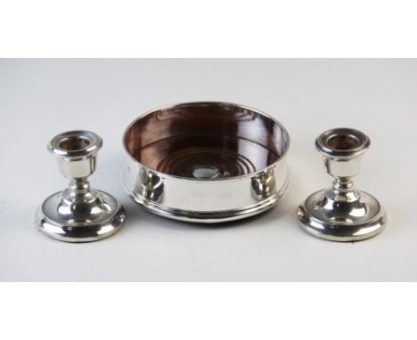 A silver mounted wine coaster London 2000, with turned oak base, 12.5cm diameter with a pair of silver dwarf candlesticks, A 