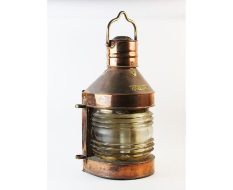 A late 19th/early 20th century ships copper masthead lantern, with a brass swing handle above a brass masthead plaque and bow