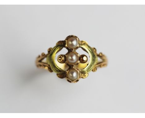 A French gold and seed pearl set ring, designed as three split pearls in a vertical setting, within a decorative scroll surro