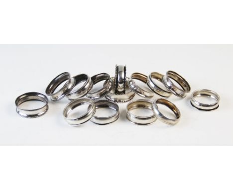 A set of four silver napkin rings 'A & J E' Birmingham 1921, each with beaded rims, a further similar example and ten further