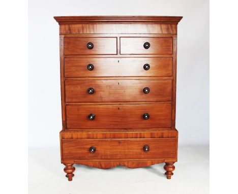 An early 19th century mahogany chest on stand, with an arrangement of two short and three long drawers flanked by inlaid geom