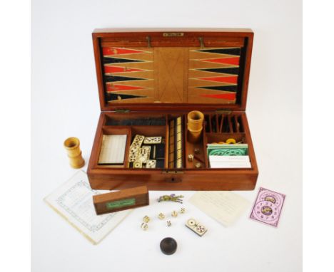 An early 20th century gaming compendium, the mahogany case enclosing a selection of games and counters to include, backgammon