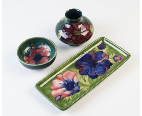 A Moorcroft squat vase, mid 20th century, decorated in an anemone pattern against a green ground, paper maker's label to base