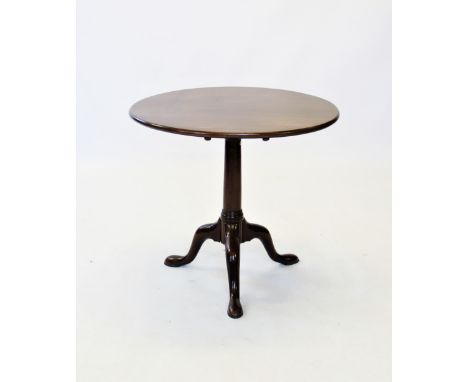 A George III mahogany tripod table, the circular tilt top raised upon a gun barrel ring turned pedestal, three down swept sup