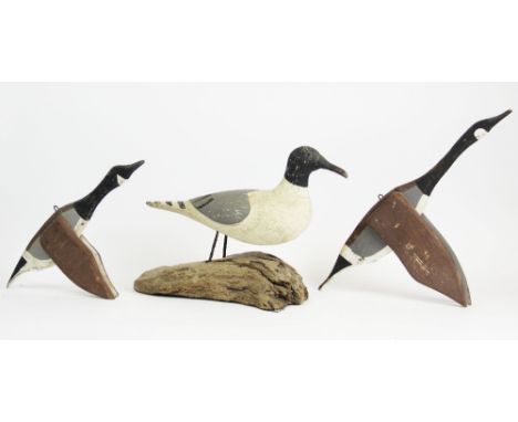 A vintage carved wooden sculpture modelled as a stylised seagull, 20th century, the body set on metal legs and mounted on a d