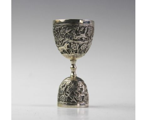 An Anglo-Indian silver double egg or wager cup, each bowl chased with a continuing landscape of exotic animals and foliage, 1