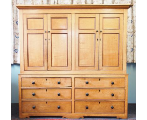 A mid 19th century honey oak housekeepers cupboard, with a cavetto cornice above two pairs of cupboard doors each applied wit