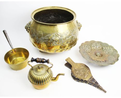 An early 20th century brass log bin, of bowl form, semi lobed and embossed with rose heads and fauna, applied with lion masks