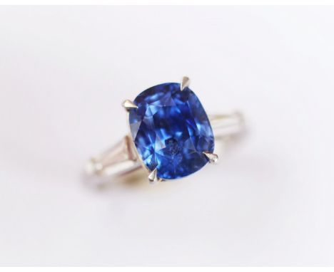 A sapphire and diamond ring, the central rectangular, cushion mixed cut sapphire within a four claw setting, the shoulders in