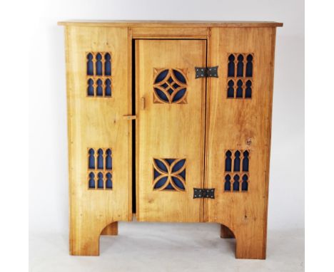 A modern light oak Gothic influence side cabinet, the central door mounted with iron butterfly hinges and centred with carved