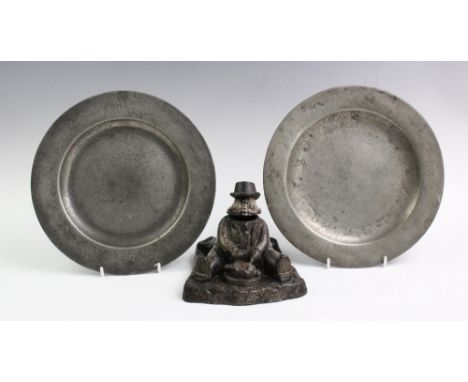A late 19th century cast iron Daniel Lambert inkwell, modelled eating seated, 15.5cm long, with two 18th century pewter plate